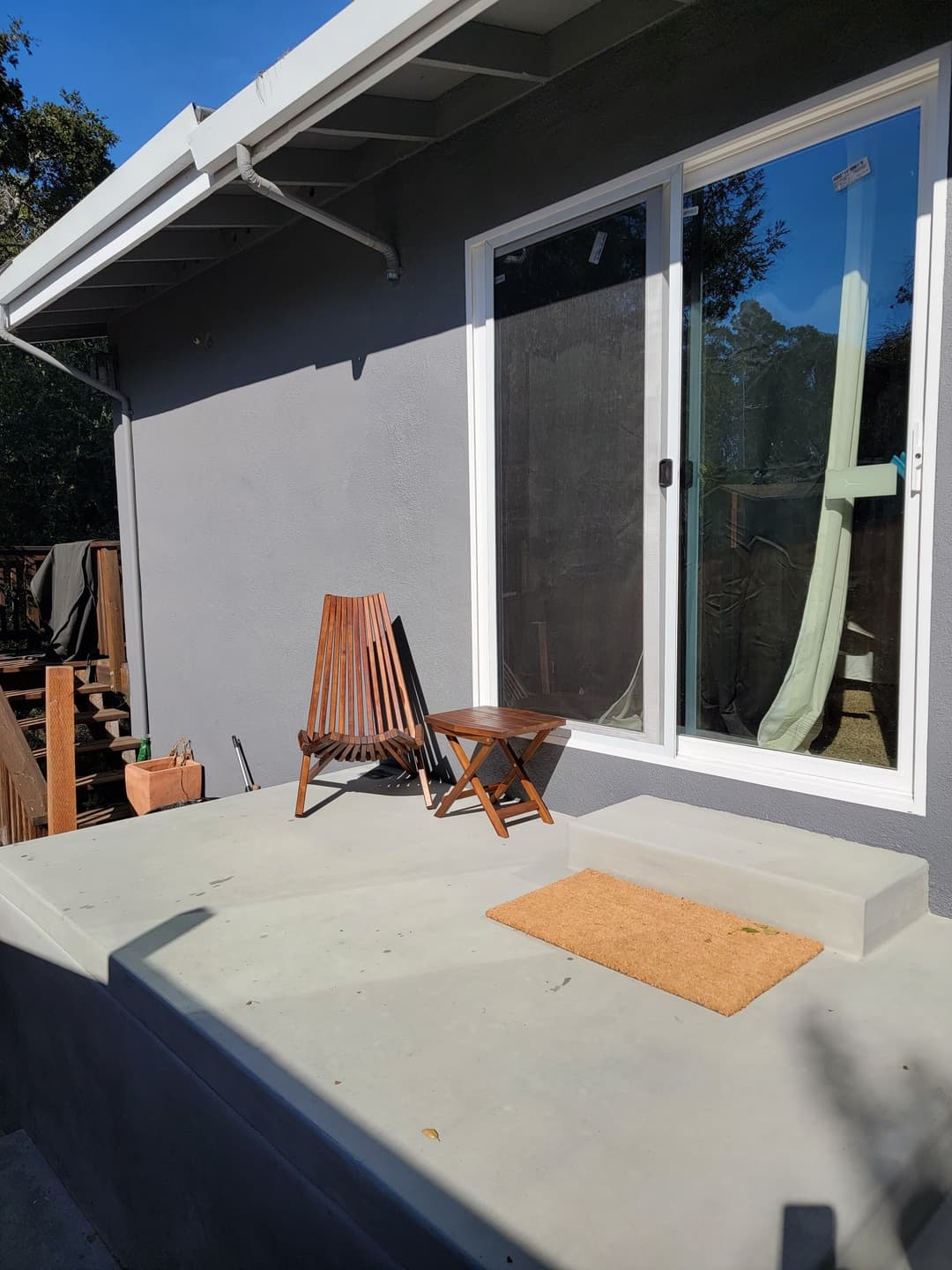 picture of a new concrete patio deck and a new patio door in the back of a home